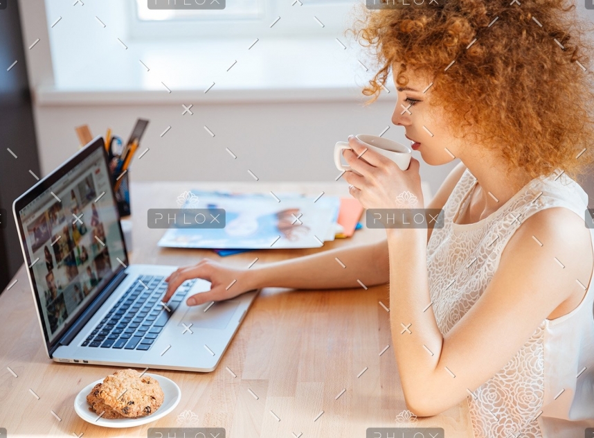 demo-attachment-493-woman-photographer-drinking-coffee-and-working-PJNBP6U